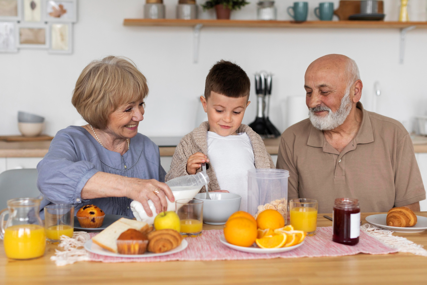 Jubilados haciendo jugo de naranja con un niño, trabajando en su emprendimiento de daycare.